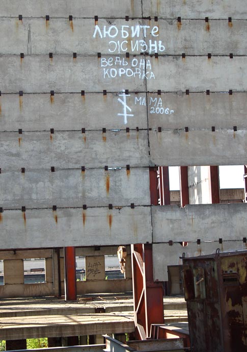 Надпись на стене заброшенного строительства - Любите жизнь, ведь она коротка (мама)